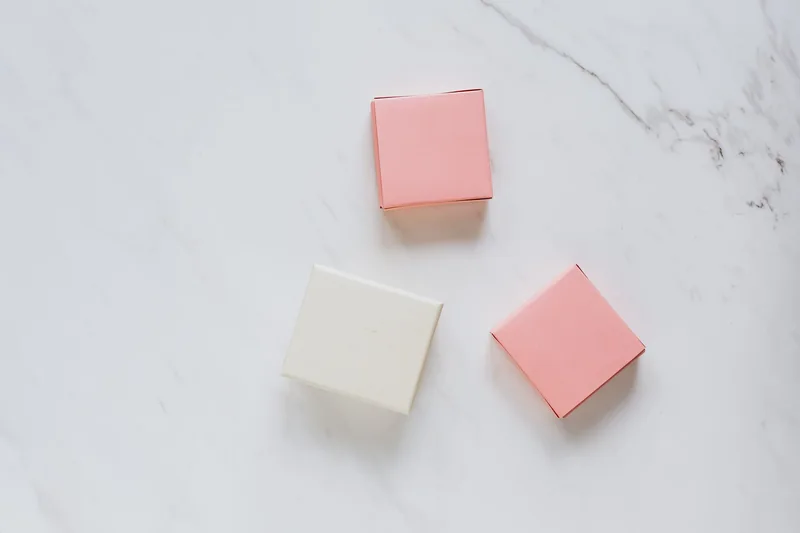 Pastel pink and white gift packaging on a marble surface — illustrative stock reference